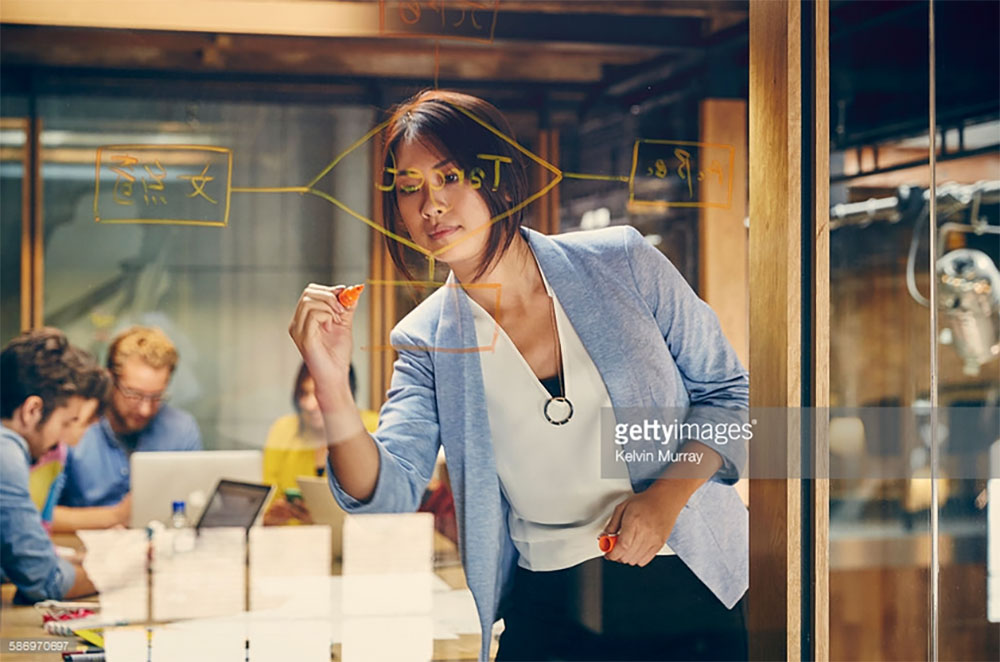 Female Professional Writing on glass wall. Photo Credit: Kelvin Murray - 586970697. gettyimages.com Why Being an INTJ Female is Great. Alwaysuttori.com